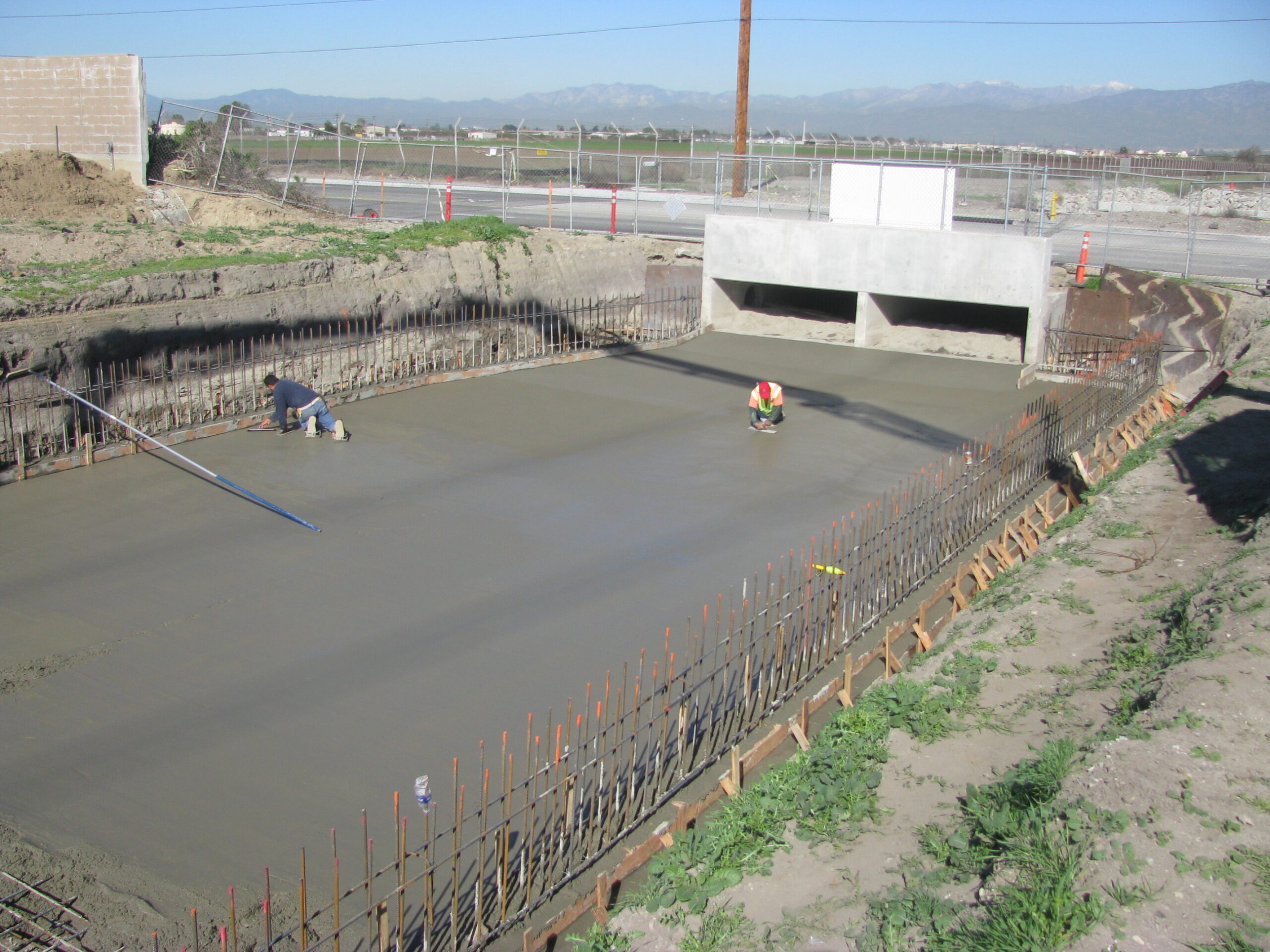 Flood control project in Inland Empire - workers laying cement