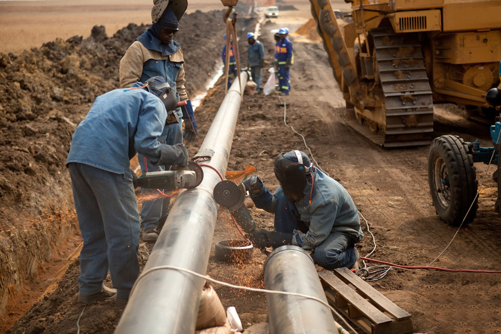 Male welders worker working on pipe